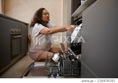 Woman unloading dishwasher in modern kitchen at home 116976191