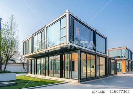 A large, modern house with a lot of glass windows and a balcony A large, modern house with a lot of glass windows and a balcony 116977302