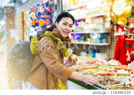 Woman choosing christmas decorations at fair 116980330