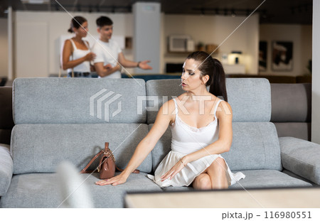 Adult woman chooses sofa in store Adult woman chooses sofa in store 116980551
