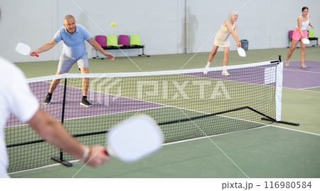 Emotional elderly man playing pickleball on indoor court Emotional elderly man playing pickleball on indoor court 116980584