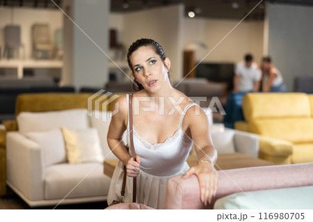 Adult woman chooses sofa in store 116980705