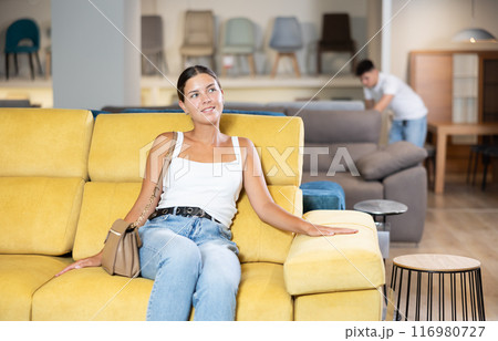Young woman chooses sofa in store 116980727