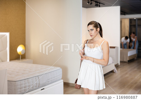 Adult woman looking around in bedroom department Adult woman looking around in bedroom department 116980887