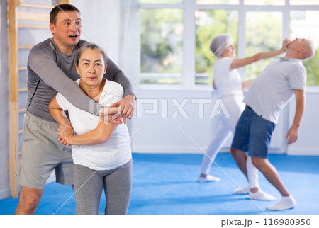 Old woman practicing self-defense techniques in pairs Old woman practicing self-defense techniques in pairs 116980950