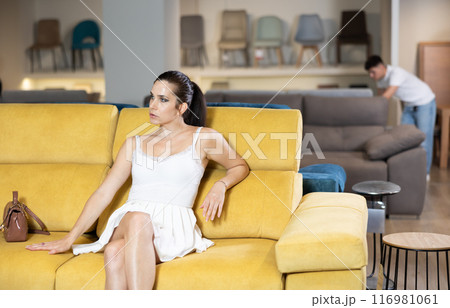 Adult woman chooses sofa in store Adult woman chooses sofa in store 116981061