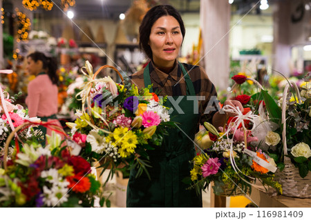 Woman flower seller prepares a luxury bouquet Woman flower seller prepares a luxury bouquet 116981409