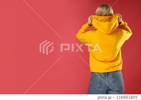 A young woman in a yellow hooded sweatshirt A young woman in a yellow hooded sweatshirt 116981805