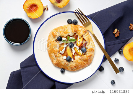 Fruit galette on plate, towel, fruit and jam on white background, top view Fruit galette on plate, towel, fruit and jam on white background, top view 116981885