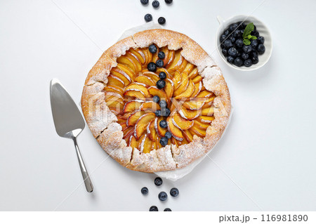 Fruit galette, scoop and berries on white background, top view 116981890