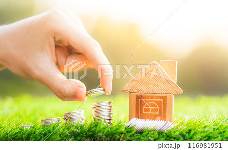 House placed on coins Men's hand is planning savings money of coins to buy a home concept concept for property ladder, mortgage and real estate investment. 116981951