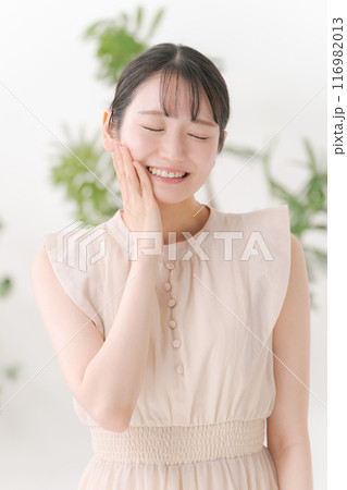 頬に手を当てる若い女性 頬に手を当てる若い女性 116982013