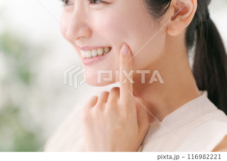 頬に手を当てる若い女性 116982221