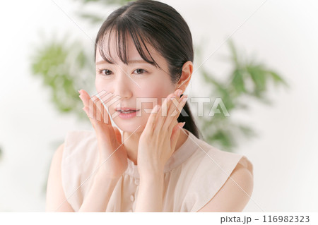 両頬を手でおさえる若い女性 116982323
