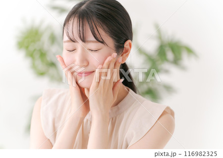 両頬を手でおさえる若い女性 両頬を手でおさえる若い女性 116982325