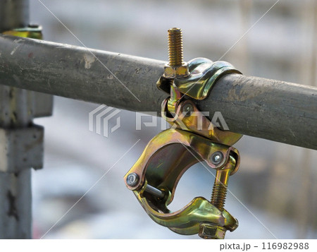 足場の単管パイプに取りつけられた連結クランプ 116982988