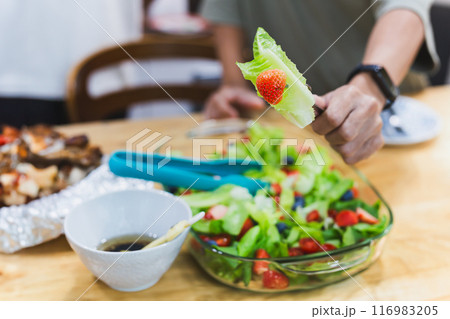 Man eating healthy vegetable and fruit salad. Man eating healthy vegetable and fruit salad. 116983205