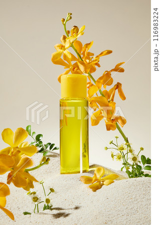 Mock up for cosmetic advertising, which has natural flower scent. A yellow liquid bottle without label displayed on white sand with some yellow orchid flowers decorated around Mock up for cosmetic advertising, which has natural flower scent. A yellow liquid bottle without label displayed on white sand with some yellow orchid flowers decorated around 116983224