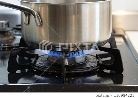 ガスコンロで料理中の手鍋 116984223