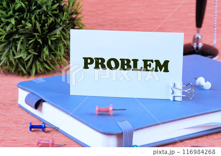 life and business negativity concept. Problem, text word on a business card standing on a notepad life and business negativity concept. Problem, text word on a business card standing on a notepad 116984268