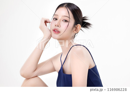 Beautiful young Asian woman with K beauty style makeup and perfect skin using lotion on isolated white background. Facial and skin care concept for commercial advertising. 116986228