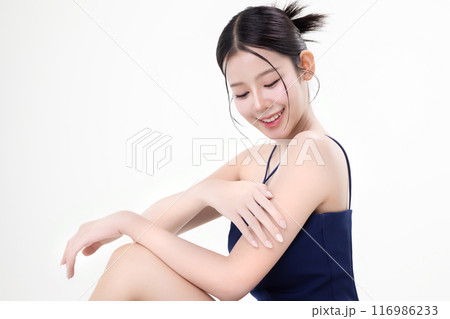 Beautiful young Asian woman with K beauty style makeup and perfect skin using lotion on isolated white background. Facial and skin care concept for commercial advertising. Beautiful young Asian woman with K beauty style makeup and perfect skin using lotion on isolated white background. Facial and skin care concept for commercial advertising. 116986233
