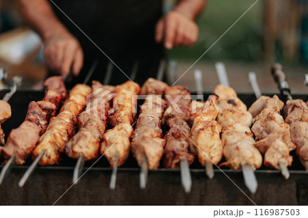 Frying shish kebab on the skewers in brazier. Fresh ruddy meat for barbecue grill on fire outdoor. Frying shish kebab on the skewers in brazier. Fresh ruddy meat for barbecue grill on fire outdoor. 116987503