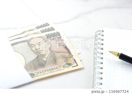福沢諭吉の肖像の一万円紙幣とメモ帳、ペン 福沢諭吉の肖像の一万円紙幣とメモ帳、ペン 116987724