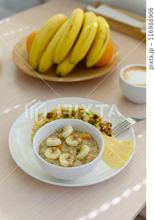 Oatmeal porridge with banana in a white bowl. Healthy breakfast food. 116988906