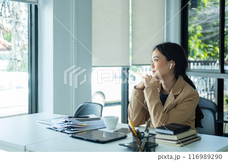 Woman listening to music while working. Woman listening to music while working. 116989290