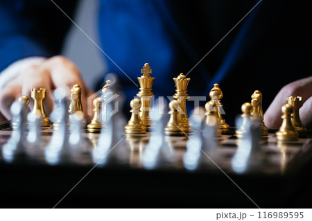 Cropped image of businessman in suit thinking over movement while sitting at glass table and playing chess 116989595