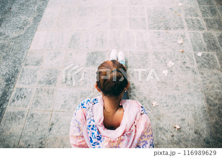 Top view of Asian determined woman in jacket sportswear stretching for flexibility in outdoor park. This exercise moves can be warm up or cool down before sports activity 116989629