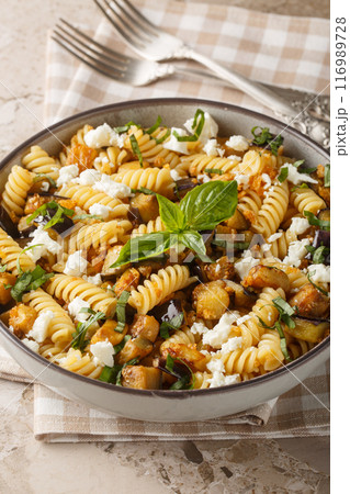 Garlicky Feta Eggplant Pasta with basil and bread crumbs closeup on the bowl. Vertical 116989728