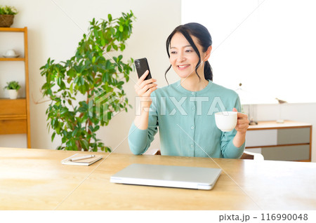 コーヒー片手にスマホを見るミドル女性 コーヒー片手にスマホを見るミドル女性 116990048