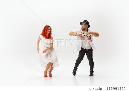 Classic dancers practice salsa passionately, perfecting each step and rhythm with dedication and energy against white studio background. 116991362