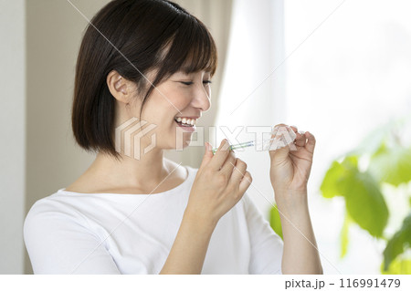 ホームホワイトニング　イメージ　マウスピースに薬剤を入れる若い女性 116991479