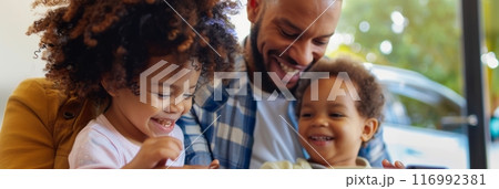 Amidst the dealership's gleaming cars, a delighted family shares hugs and laughter, their eyes sparkling with joy and anticipation of new adventures, banner 116992381