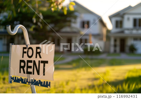 Sign FOR RENT on a green clearing against the background of a house for rent 116992431