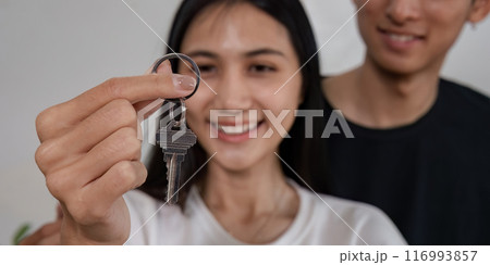 Happy Couple Holding Keys to New Home, Celebrating Moving Day and New Beginnings 116993857