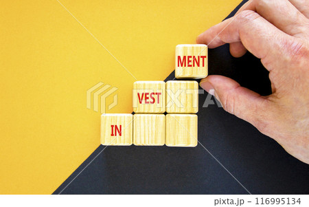 Investment symbol. Concept word Investment on beautiful wooden blocks. Businessman hand. Beautiful yellow and black background. Business investment concept. Copy space. Investment symbol. Concept word Investment on beautiful wooden blocks. Businessman hand. Beautiful yellow and black background. Business investment concept. Copy space. 116995134