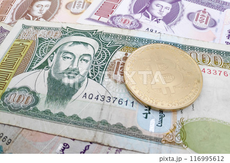Bitcoin on a stack of Mongolian Togrog banknotes 116995612