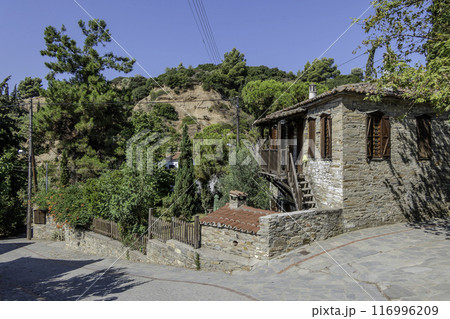 Greece, Nikiti, Street of the old town of Nikiti with its stone houses. 116996209