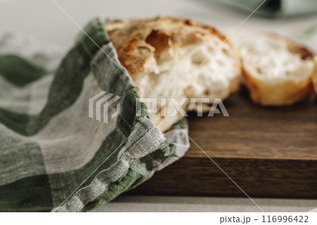 Sliced bread on wooden board in linen bag close up. Kitchen aesthetic concept 116996422
