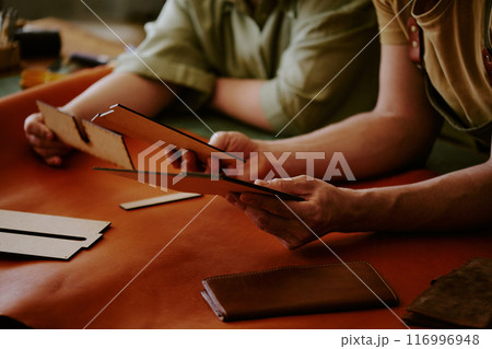 Unrecognizable male and female hands holding wooden shape to use them as stencil Unrecognizable male and female hands holding wooden shape to use them as stencil 116996948