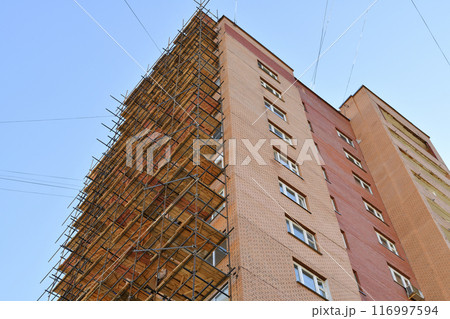A brick house under construction with wooden scaffolding A brick house under construction with wooden scaffolding 116997594