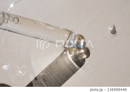 Pipette with serum on a beige background. 116998446