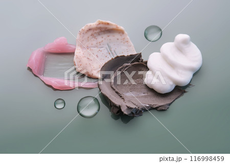 Textures of different cosmetic products on a green background. 116998459