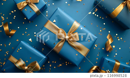 Beautifully wrapped blue gifts with golden bows and ribbons surrounded by confetti 116998528