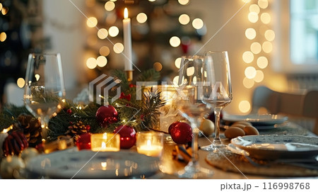 festive table with candles, glassware, and Christmas ornaments 116998768