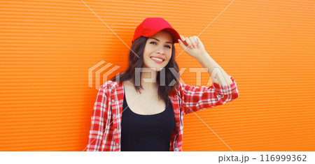 Summer portrait of happy smiling young woman posing in red baseball cap, casual clothes Summer portrait of happy smiling young woman posing in red baseball cap, casual clothes 116999362